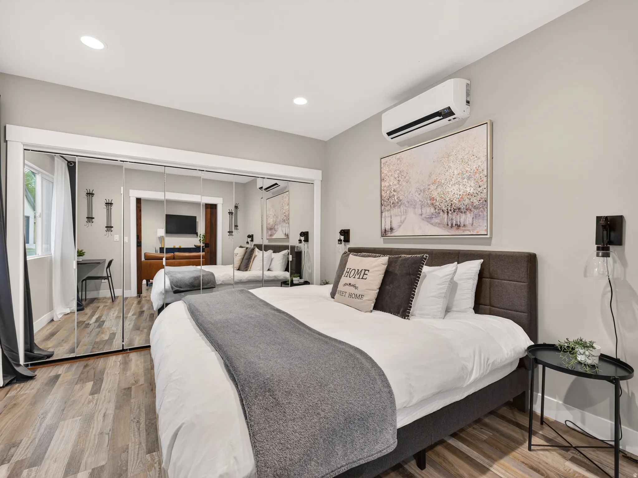 Bedroom featuring wood-finish flooring, recessed lighting, and a wall-mounted mini-split HVAC unit