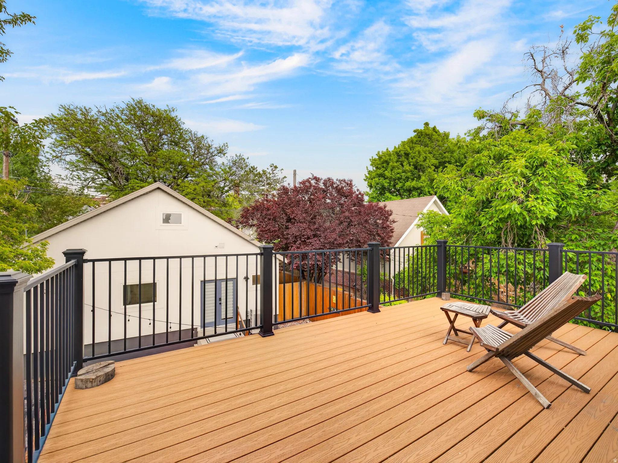 Spacious outdoor deck featuring wood-finish decking and black iron railings