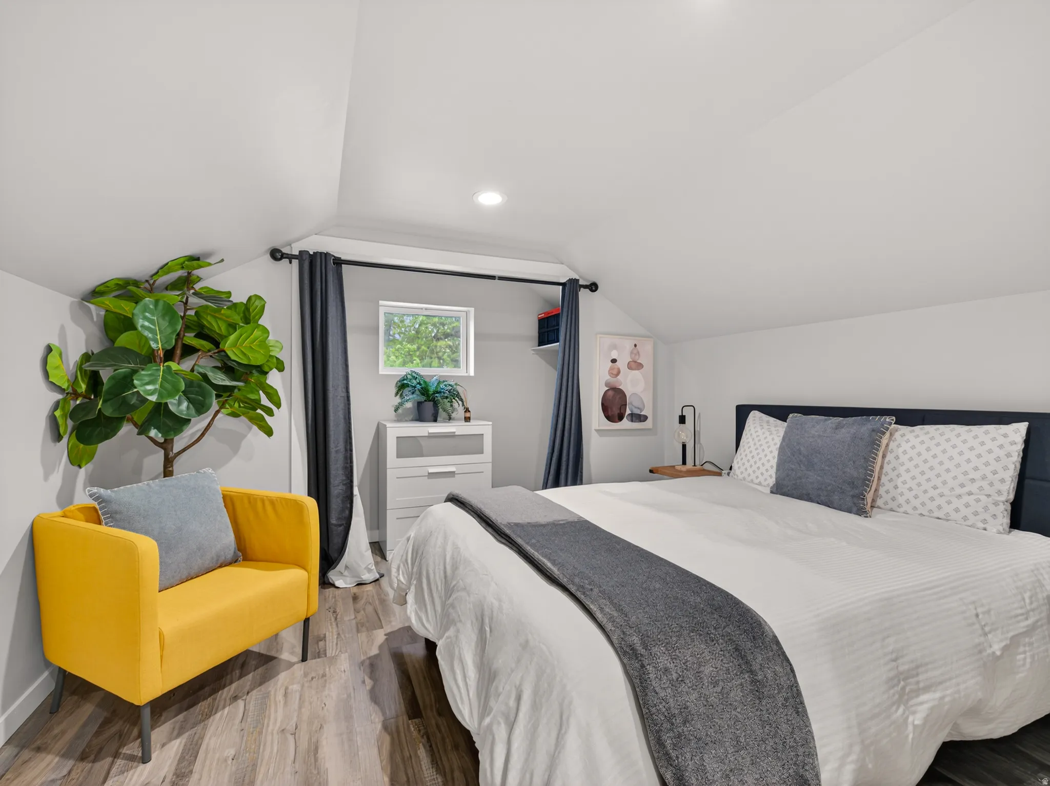 Bedroom featuring wood-finish flooring, a window with natural light, and a built-in recessed light fixture