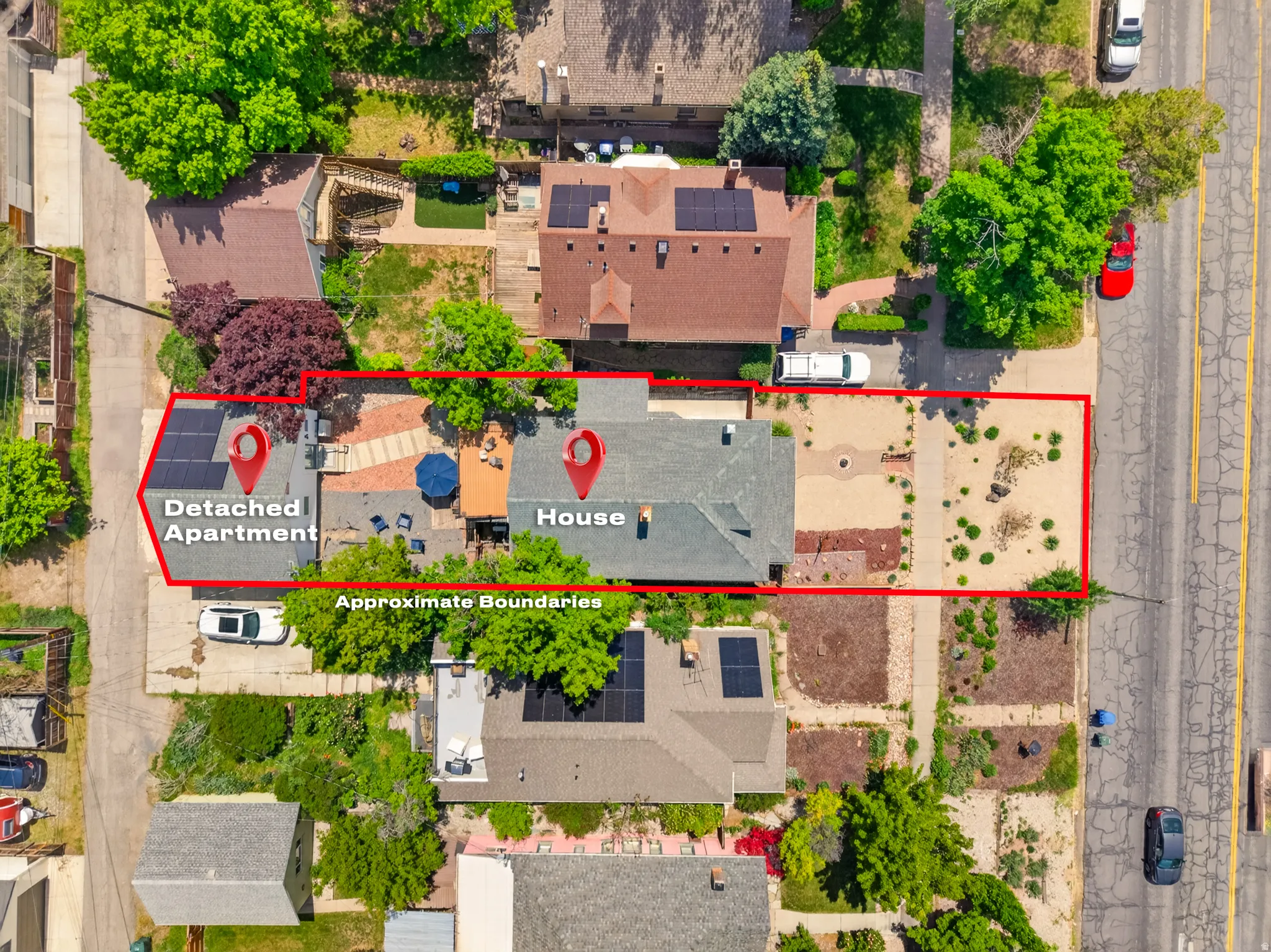 Aerial perspective showcasing the primary residence, a detached apartment with solar panels, and an outdoor patio space