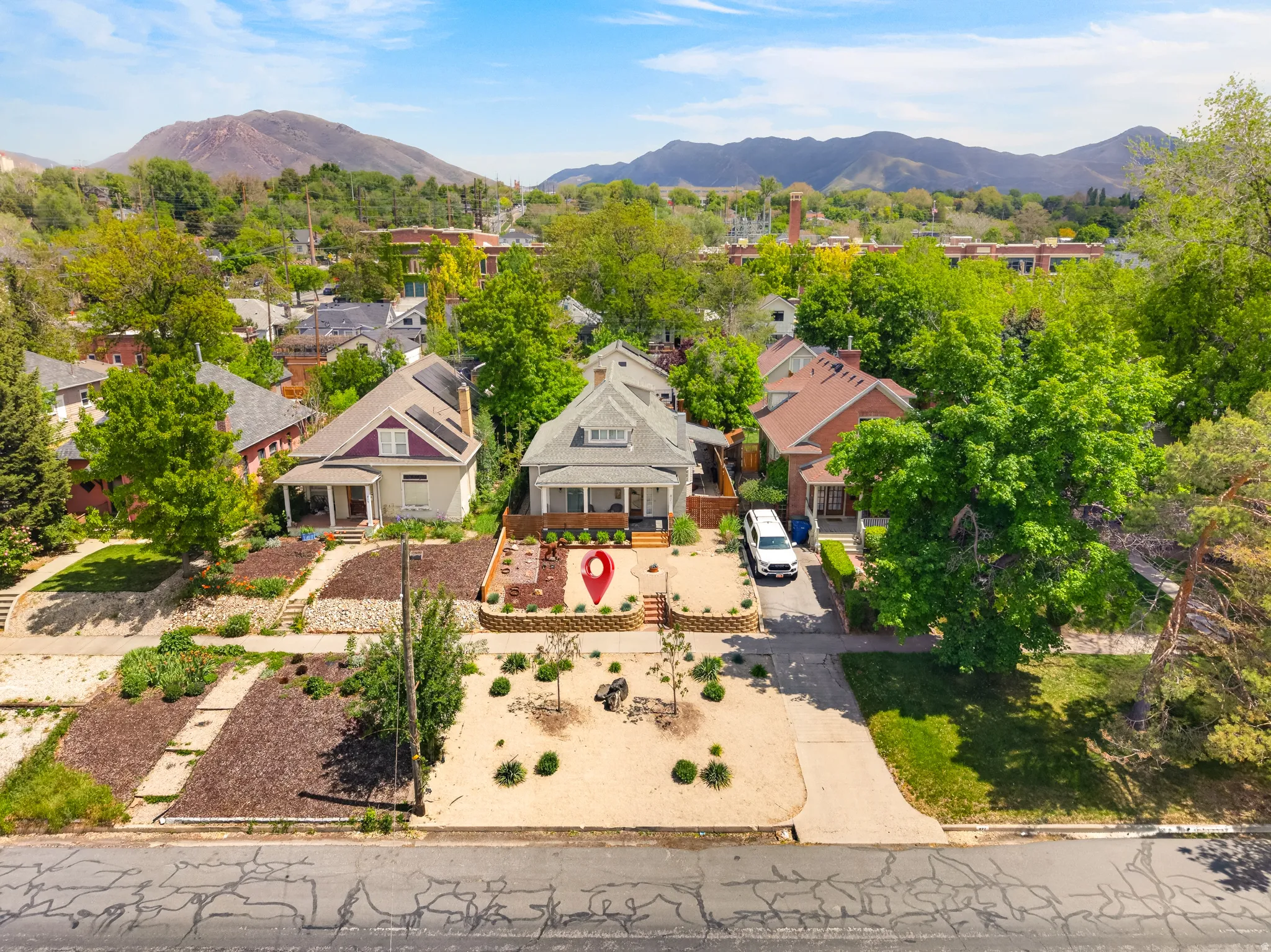 Traditional residential architecture with a covered front porch, a gravel driveway, and a terraced front yard