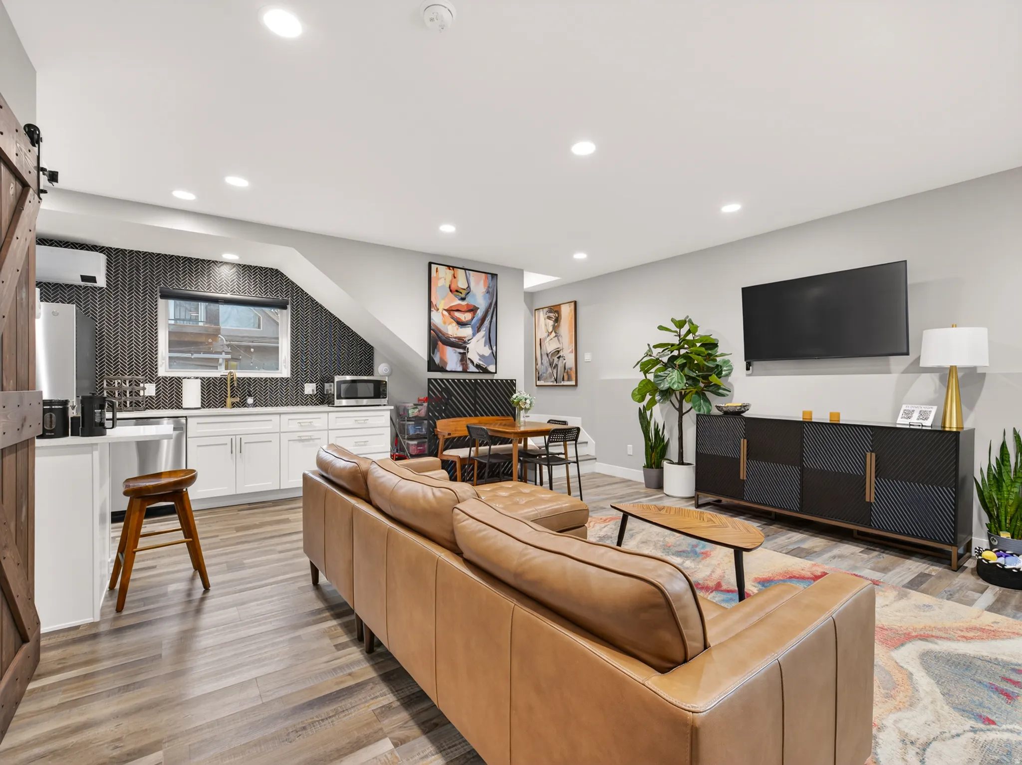 Open concept living space featuring wood-finish flooring, recessed lighting, and light gray walls