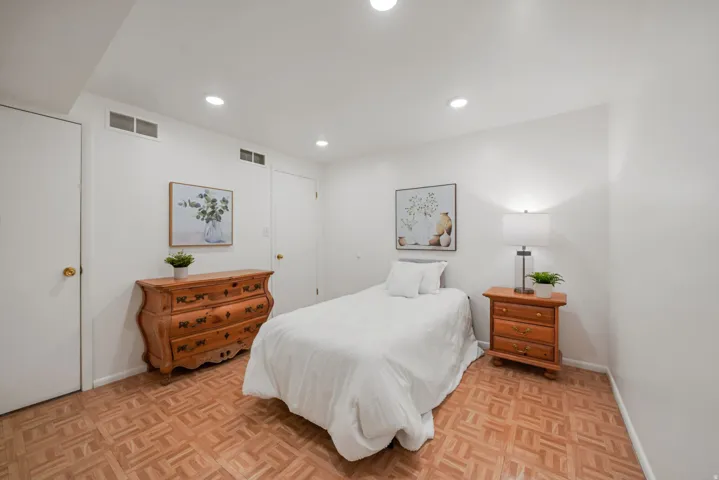 Bright room featuring parquet wood flooring, recessed lighting, and white walls