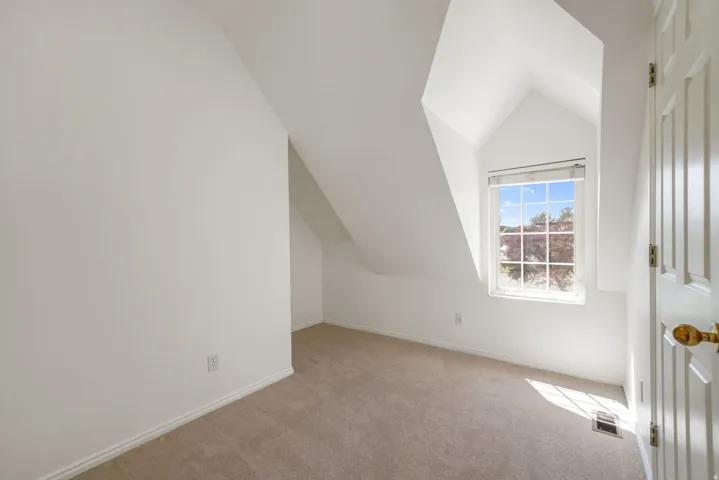 Room featuring white painted walls and sloped ceilings