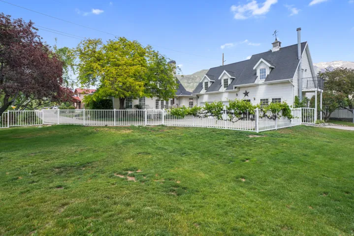 Expansive green lawn with a white picket fence