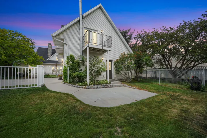 White siding exterior with a second-story balcony featuring black metal railings