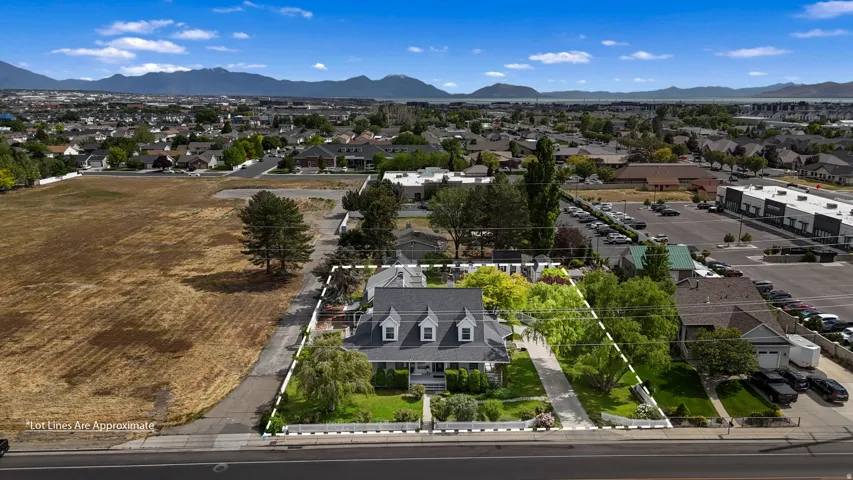 Expansive property featuring a classic multi-story residence with a dark shingle roof and dormer windows