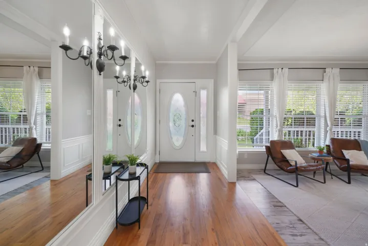 Entryway featuring wood-finish flooring, white wainscoting, and an oval frosted glass entry door