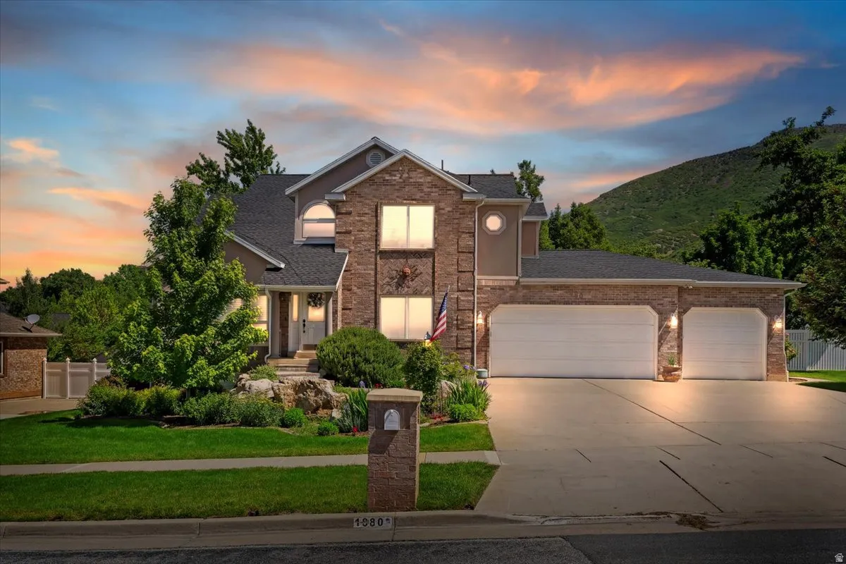 Stately two-story residence featuring a stone and stucco facade, a two-car garage, and a concrete driveway