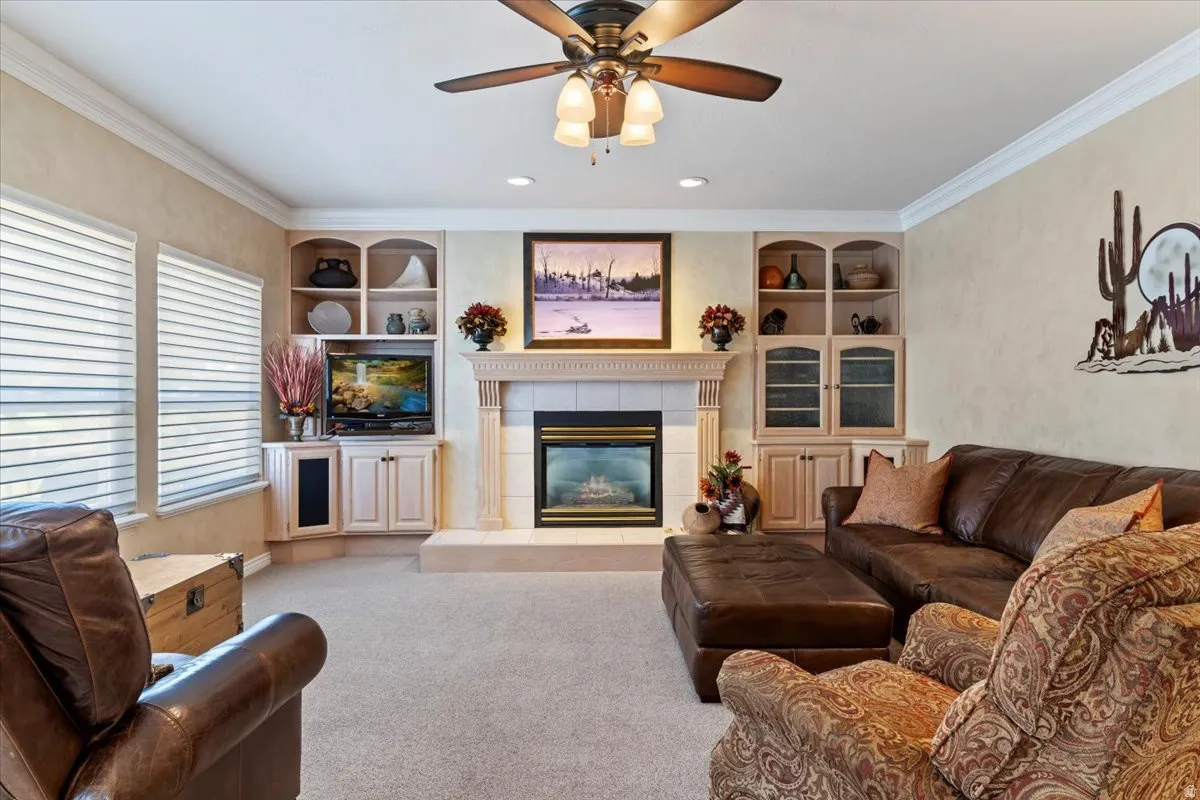 Living space featuring a central fireplace with a tile hearth and mantel, flanked by built-in cabinetry and shelving