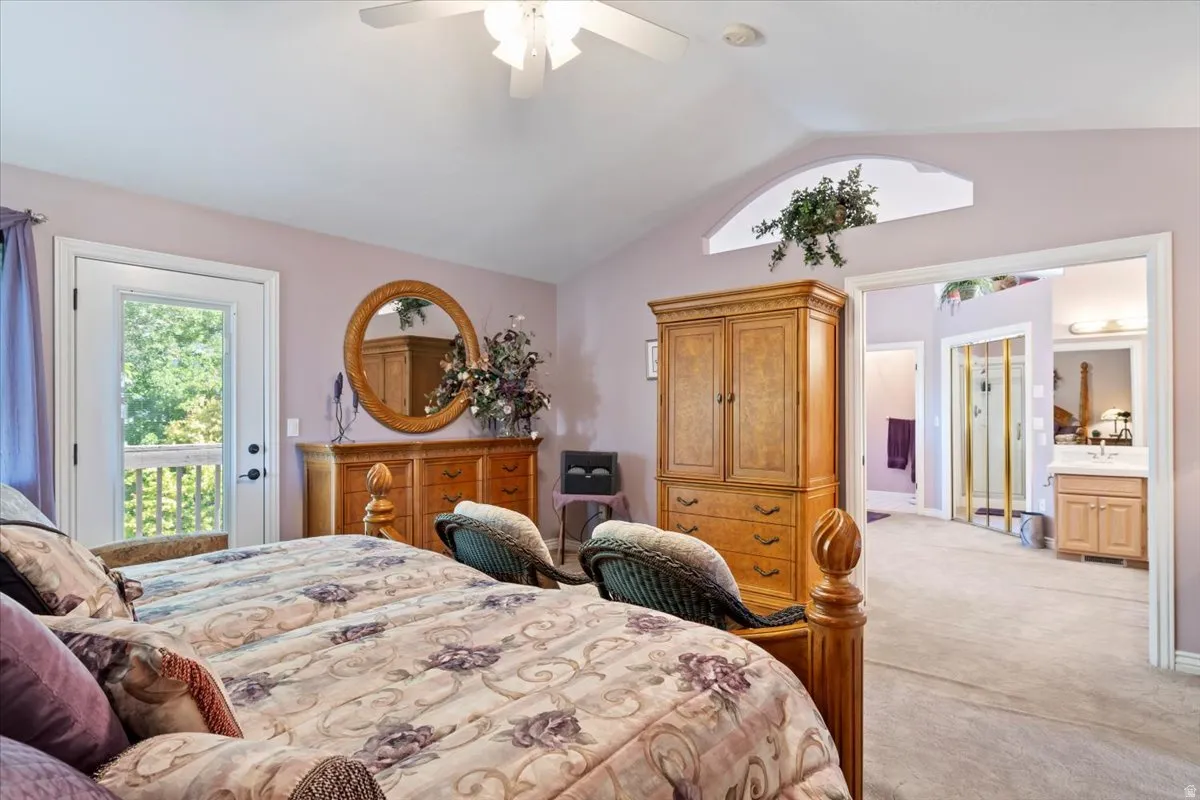 Carpeted bedroom with a vaulted ceiling and an arched transom window