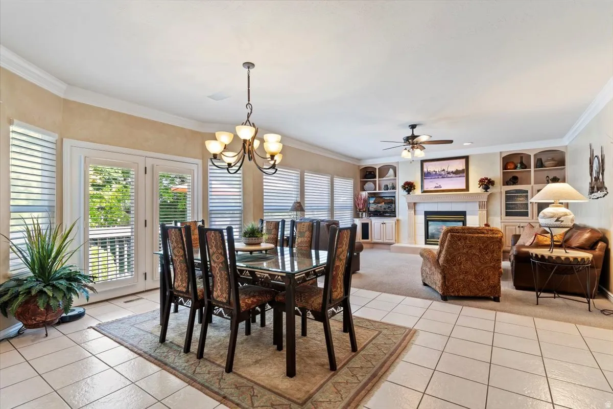 Open-concept living space with tile flooring, a built-in fireplace, and custom shelving
