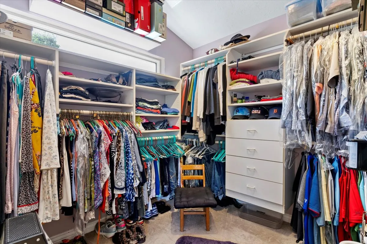 Custom closet system featuring multiple hanging rods, integrated shelving, and built-in drawers