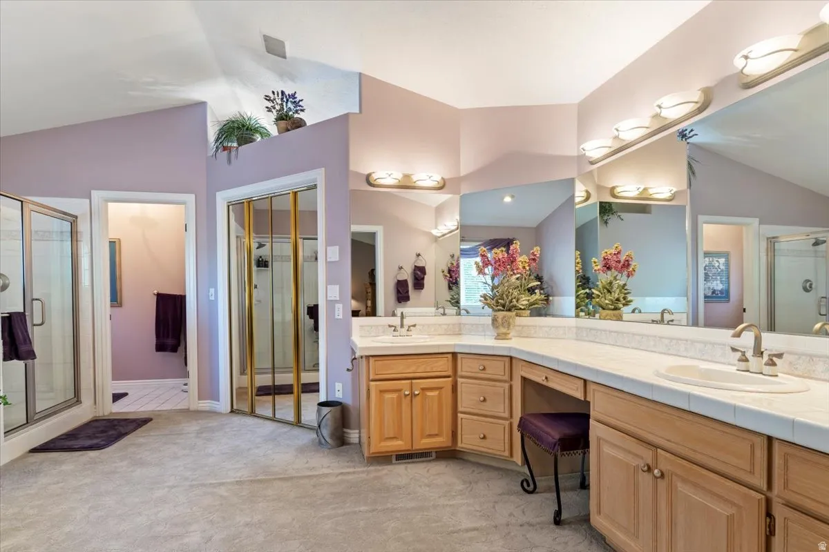 Spacious bathroom featuring a dual vanity with integrated sinks, ample counter space, and extensive mirrored wall