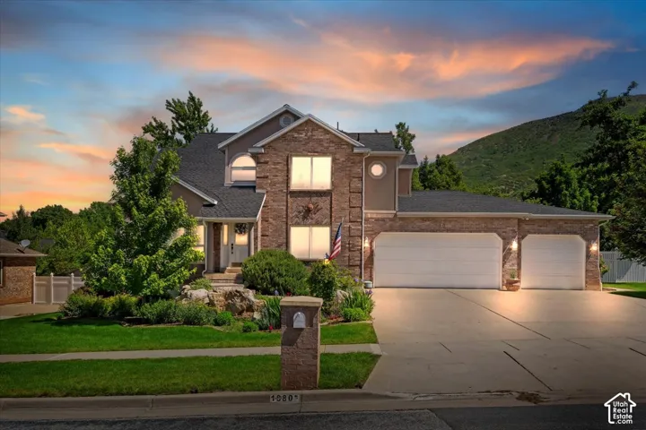 Stately two-story residence featuring a stone and stucco facade, a two-car garage, and a concrete driveway