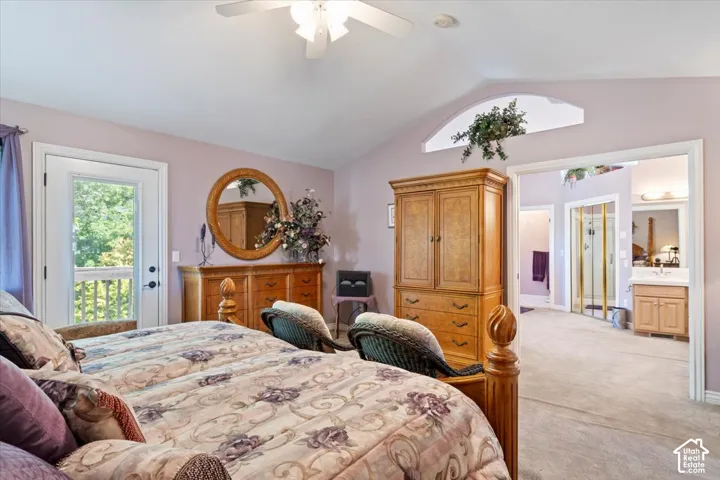 Carpeted bedroom with a vaulted ceiling and an arched transom window
