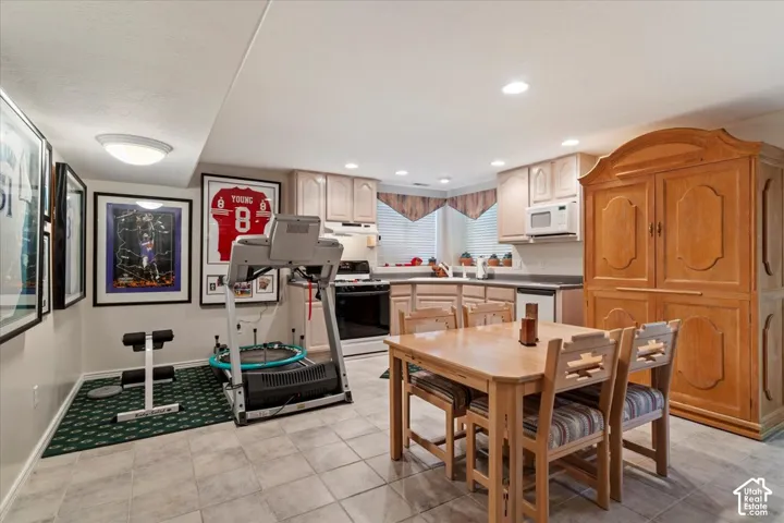 Well-appointed kitchen area featuring light wood cabinetry, dark countertops, and tile flooring