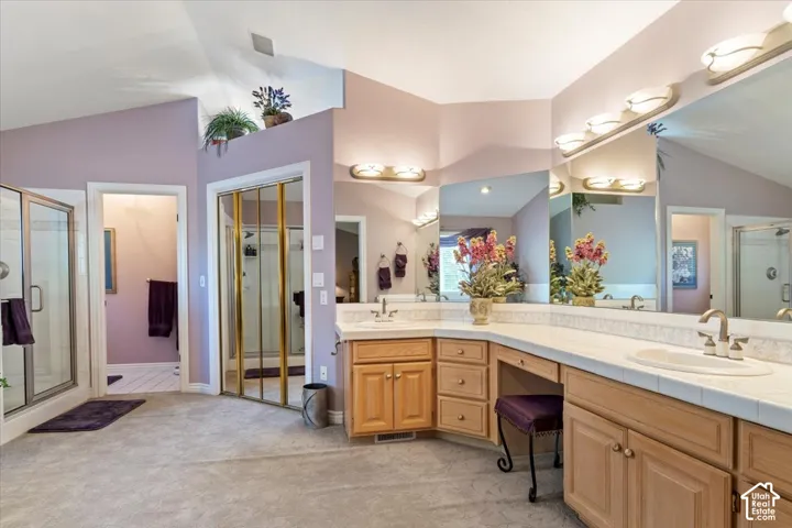 Spacious bathroom featuring a dual vanity with integrated sinks, ample counter space, and extensive mirrored wall