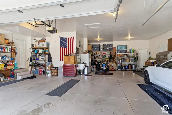 Spacious garage featuring concrete flooring and two garage door openers