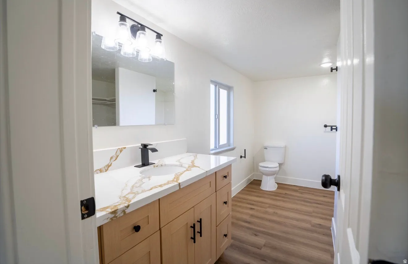 Bathroom vanity featuring a quartz countertop with gold veining, a matte black faucet, and a rectangular undermount sink