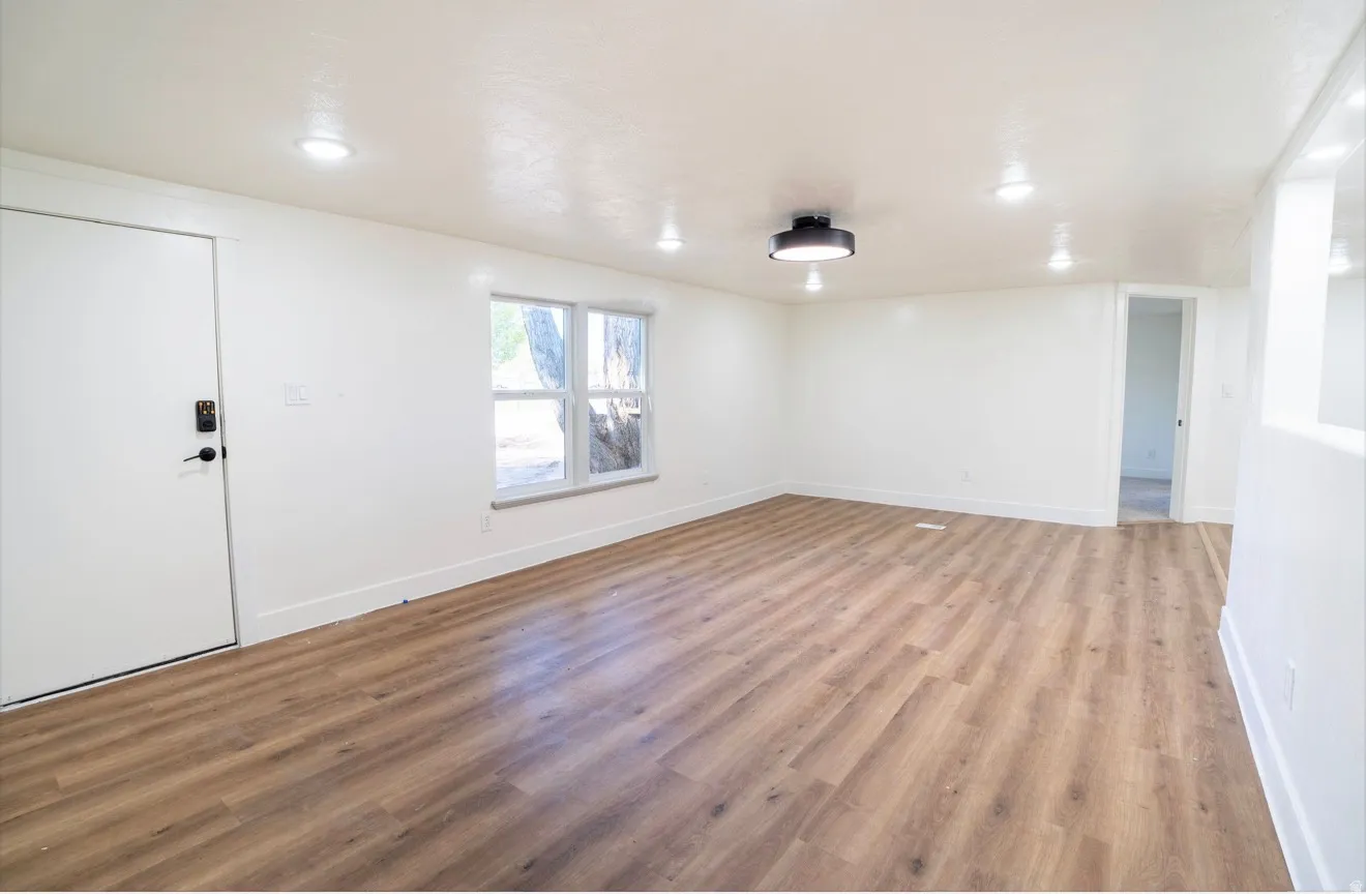 Spacious interior featuring wood-finish flooring, recessed lighting, and a modern ceiling fixture