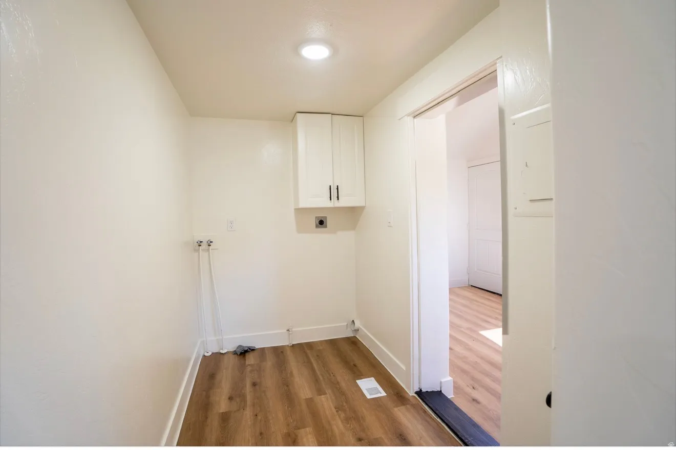 Utility area featuring wood-finish flooring, white walls, and a recessed ceiling light
