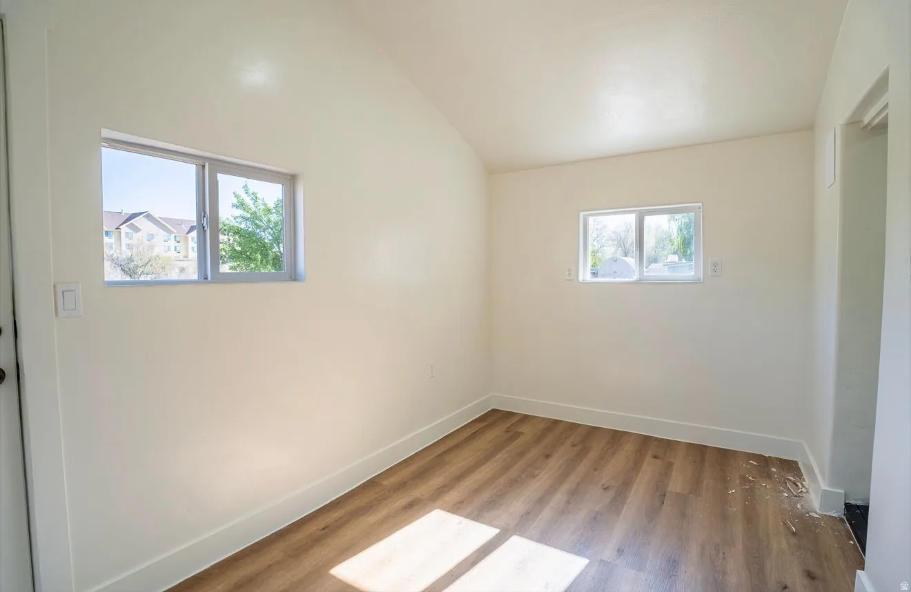 Interior room featuring wood-finish flooring, neutral wall tones, and white trim