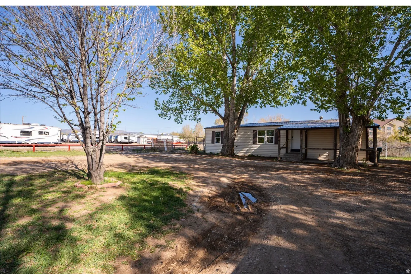Single-story manufactured home featuring a covered front porch, white siding, and a metal roof
