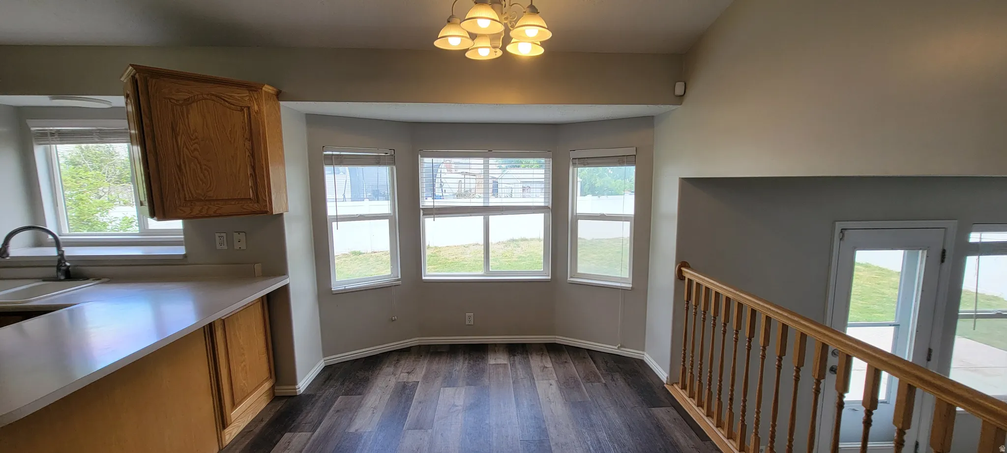 Dining area featuring a bay window, wood-finish flooring, and a multi-light ceiling fixture