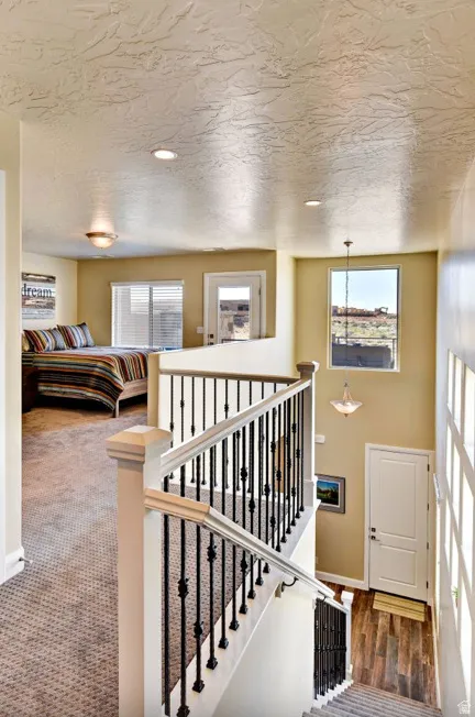 Staircase featuring white newel posts and handrails with black decorative metal balusters