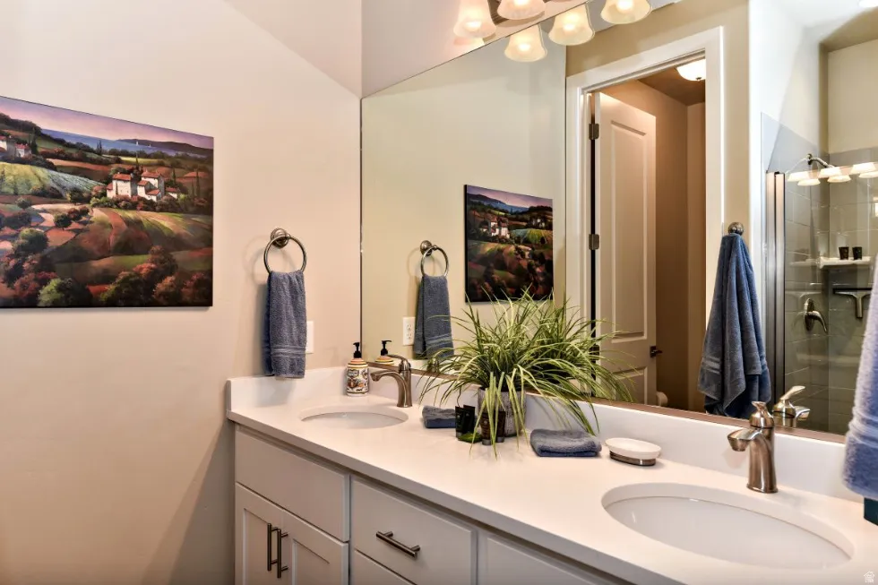 Bathroom featuring a double vanity with white countertops, undermount sinks, brushed nickel faucets, and coordinating cabinet hardware
