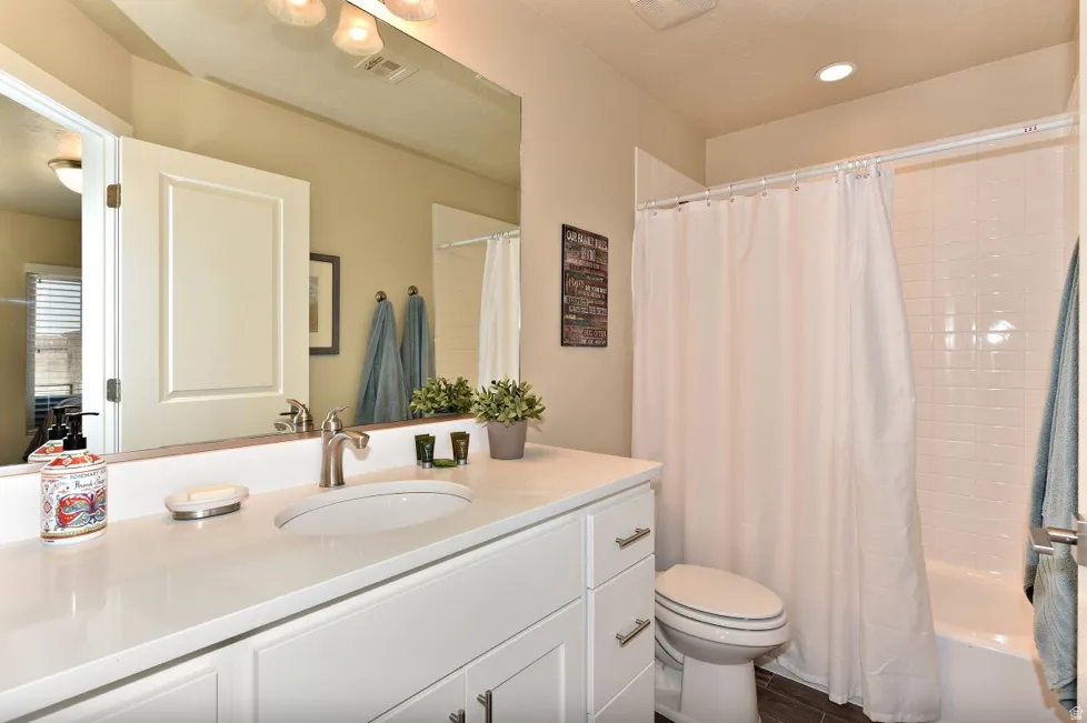 Bathroom featuring a white vanity with an undermount sink, brushed nickel faucet, and a large wall-mounted mirror