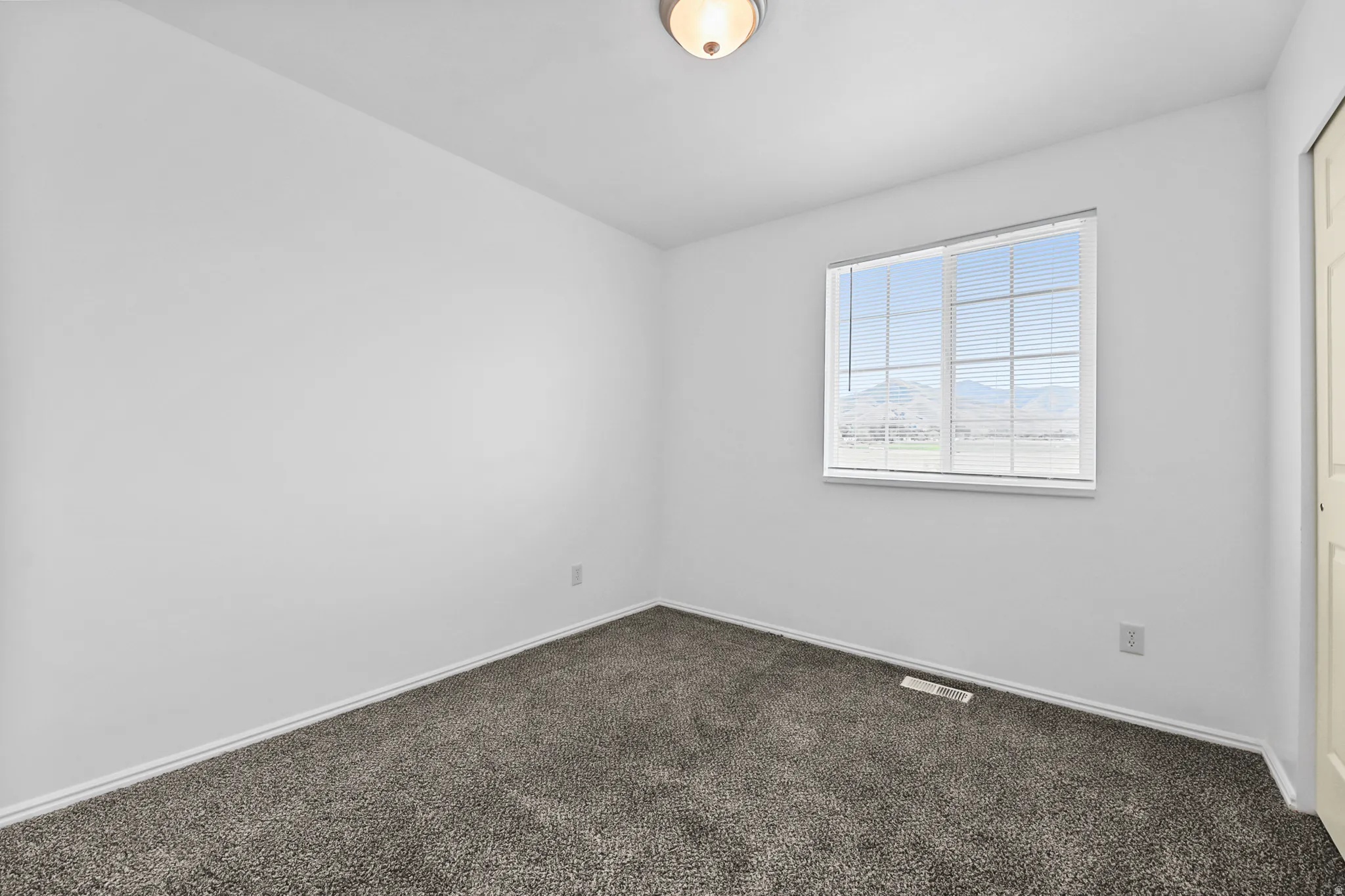 Bedroom featuring light gray carpeting and white walls