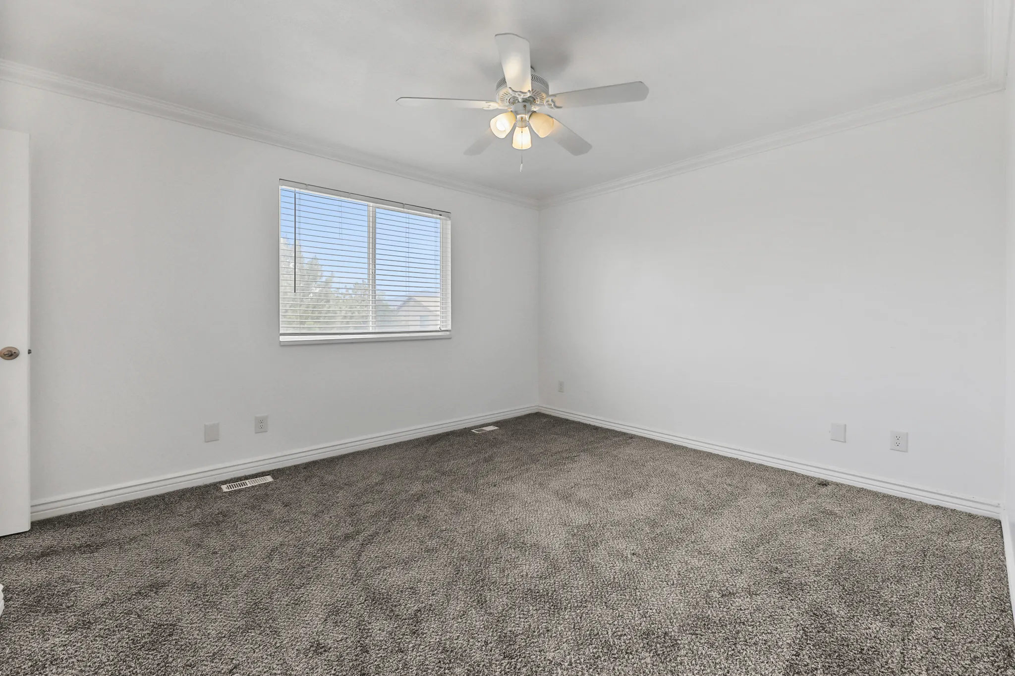 Spacious room featuring neutral carpeting and white walls