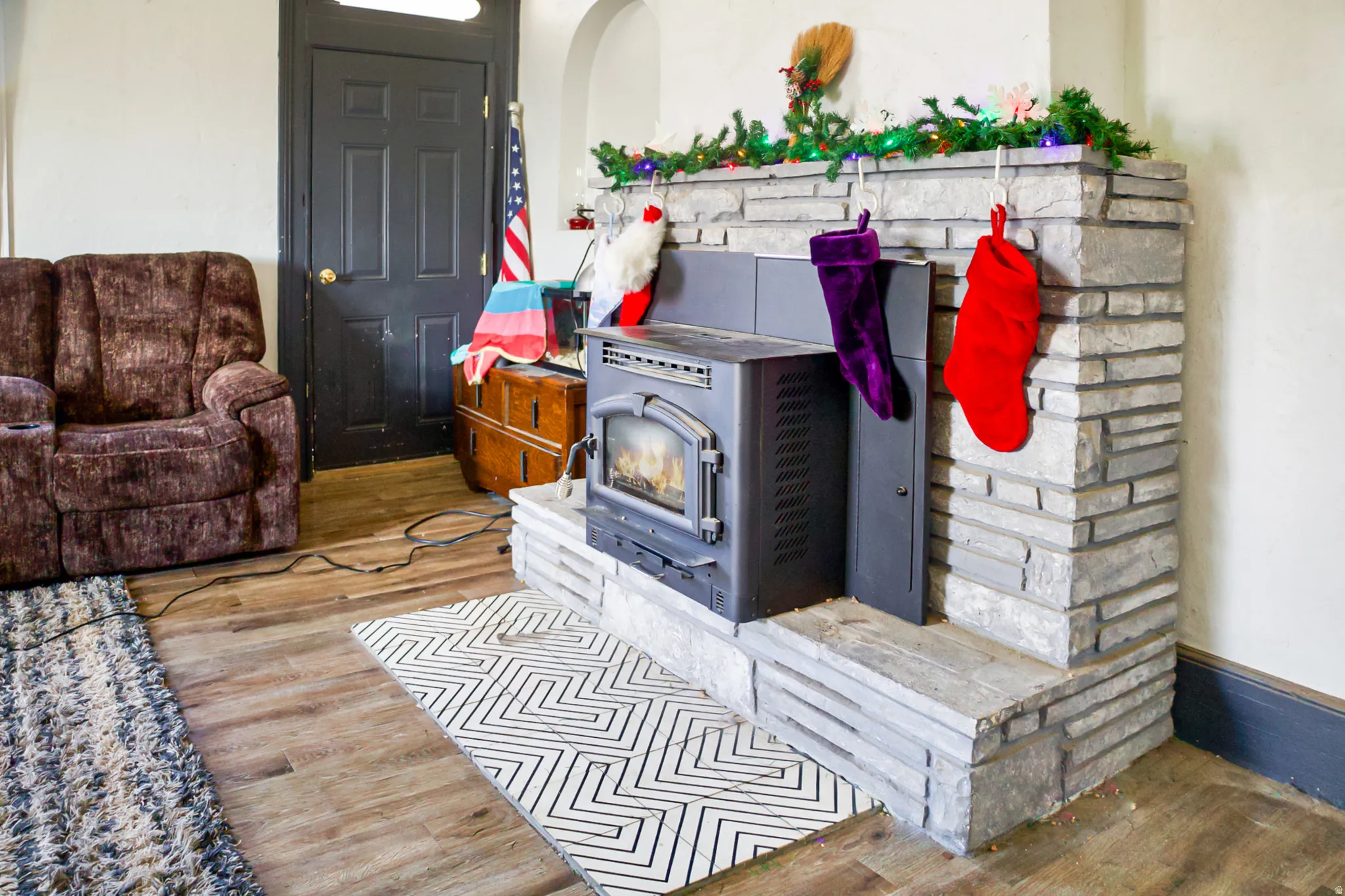 Stone-clad fireplace featuring a pellet stove insert