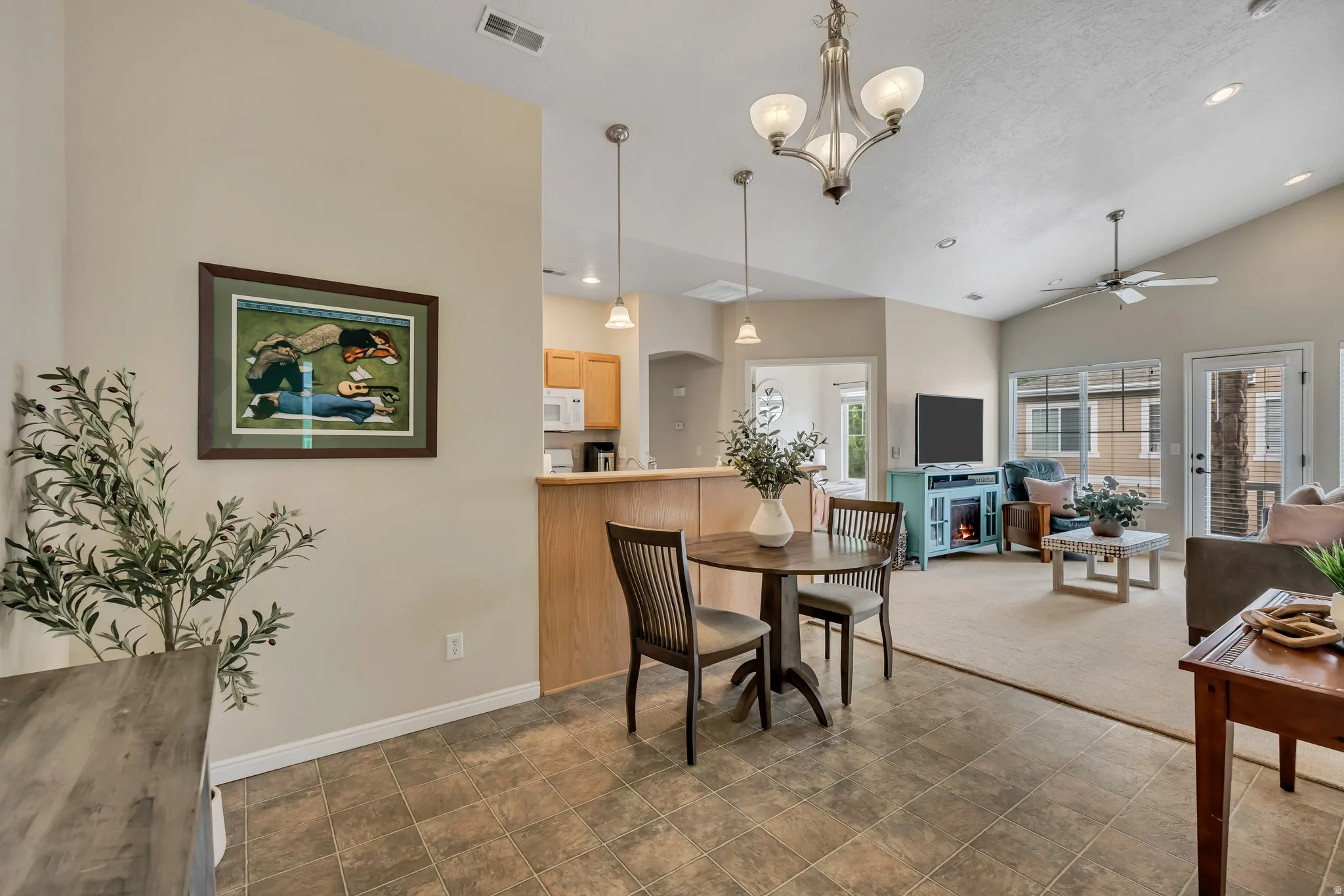 Open-concept living space with vaulted ceilings, recessed lighting, a ceiling fan, and great natural light.