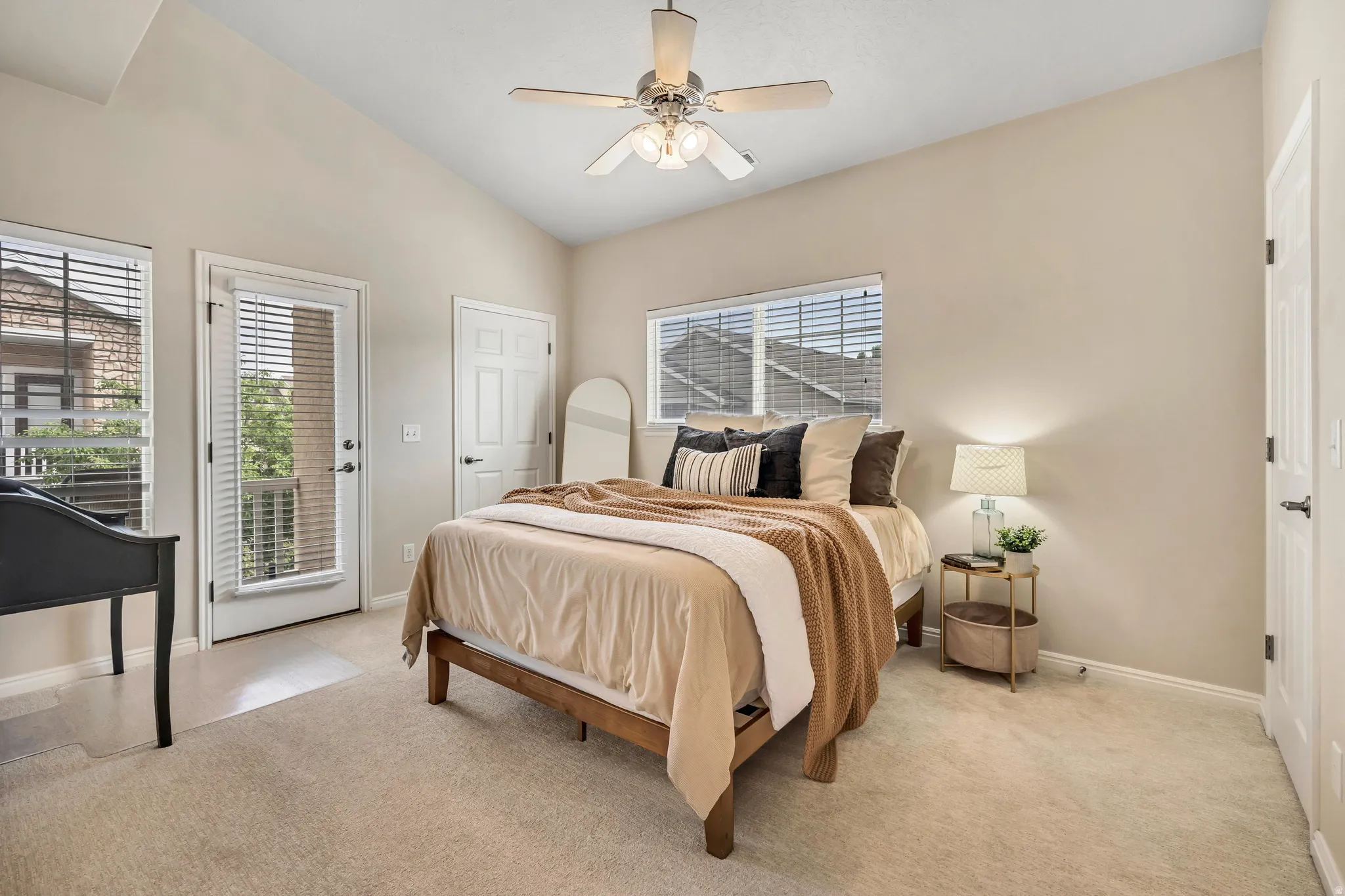 Main bedroom suite with vaulted ceiling, double walk-in closets, walk-out to deck, full bathroom with dual vanity.