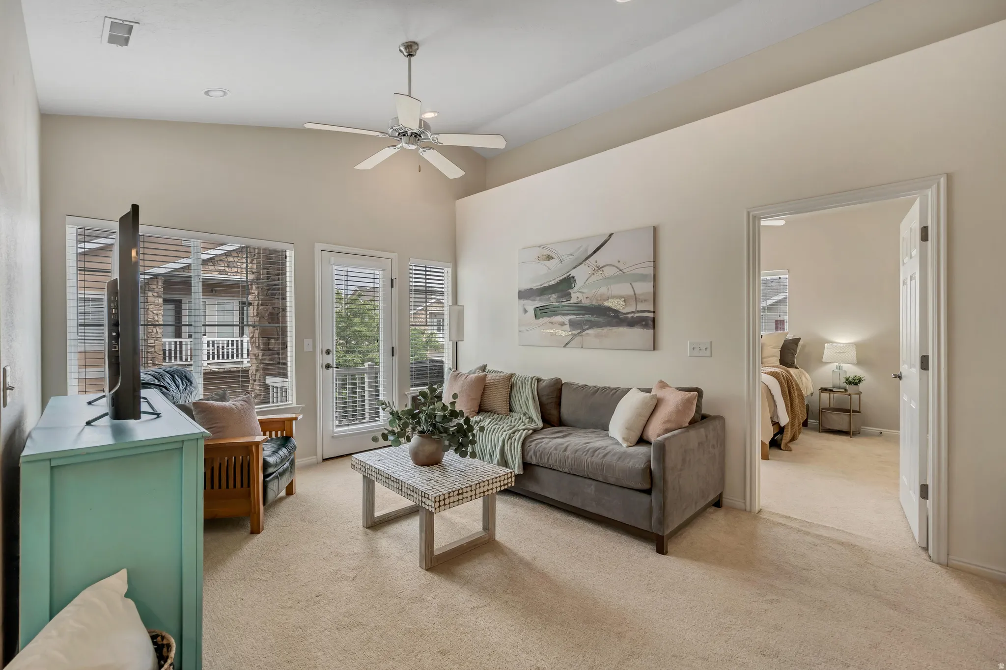 Living area featuring vaulted ceilings, recessed lighting, walkout to the deck, and freshly cleaned carpet flooring.