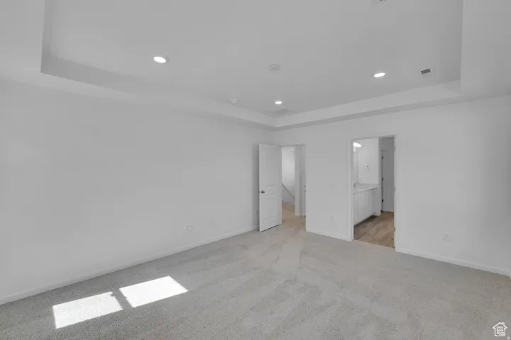 Spacious room featuring light gray carpeting and white walls