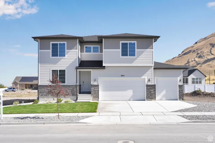 Contemporary two-story residence featuring light gray siding and stone accents
