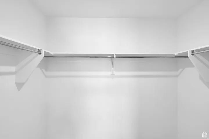 White interior closet featuring multiple upper shelves and clothing rods