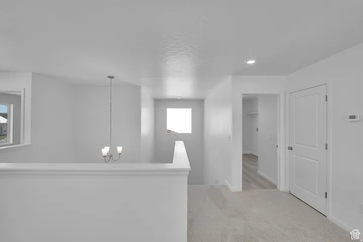 Upper-level landing featuring light gray carpeting and white painted walls
