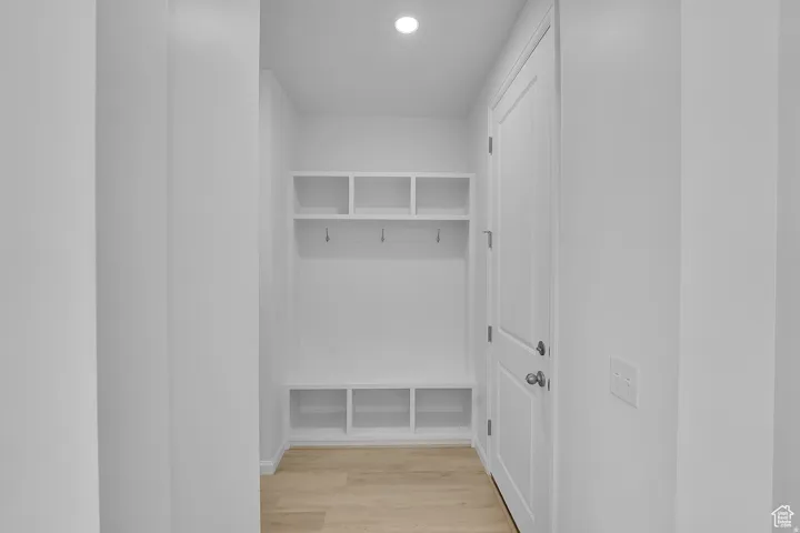 Built-in white storage unit featuring overhead cubbies, coat hooks, and lower cubbies
