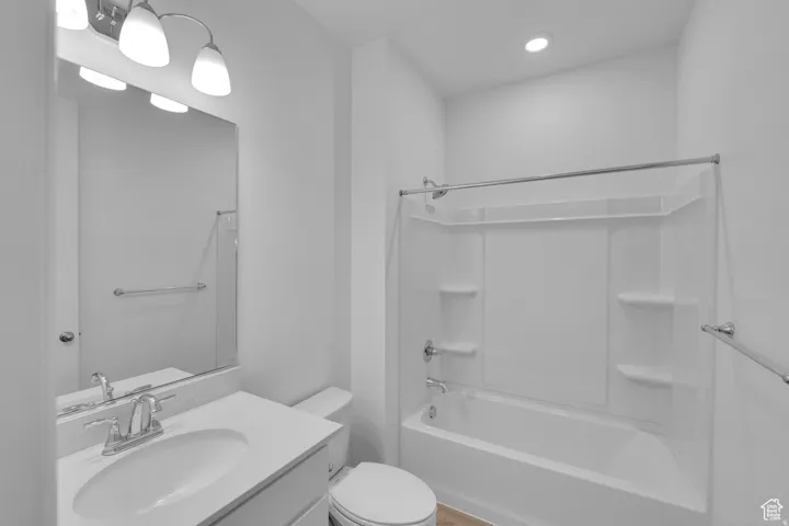 Full bathroom featuring a white vanity with an integrated sink, polished chrome faucet, and a wall-mounted mirror