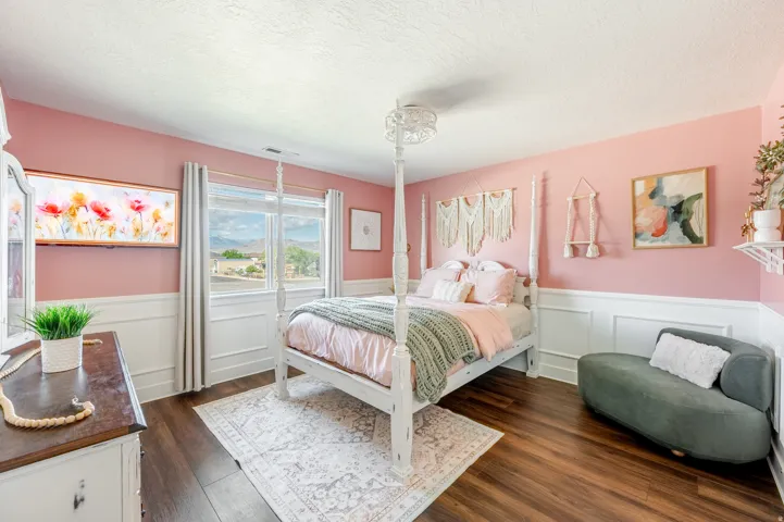 Wood-finish flooring, wainscoting, and large windows with privacy curtains