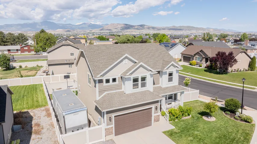 Two-story residence featuring a covered front porch, an attached two-car garage, and a fenced backyard