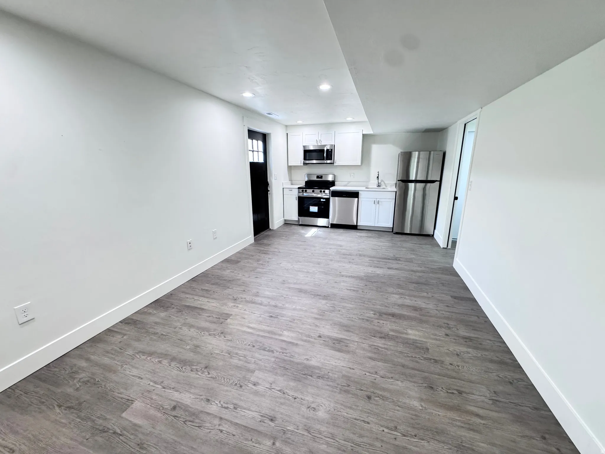 Open-concept living space featuring wood-finish flooring and recessed lighting
