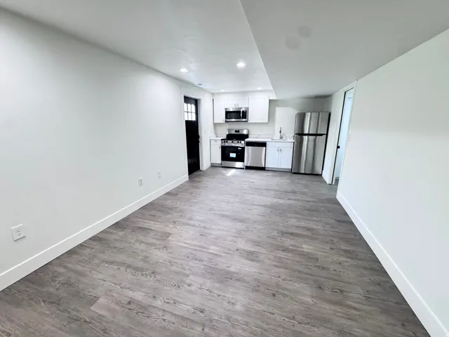 Open-concept living space featuring wood-finish flooring and recessed lighting
