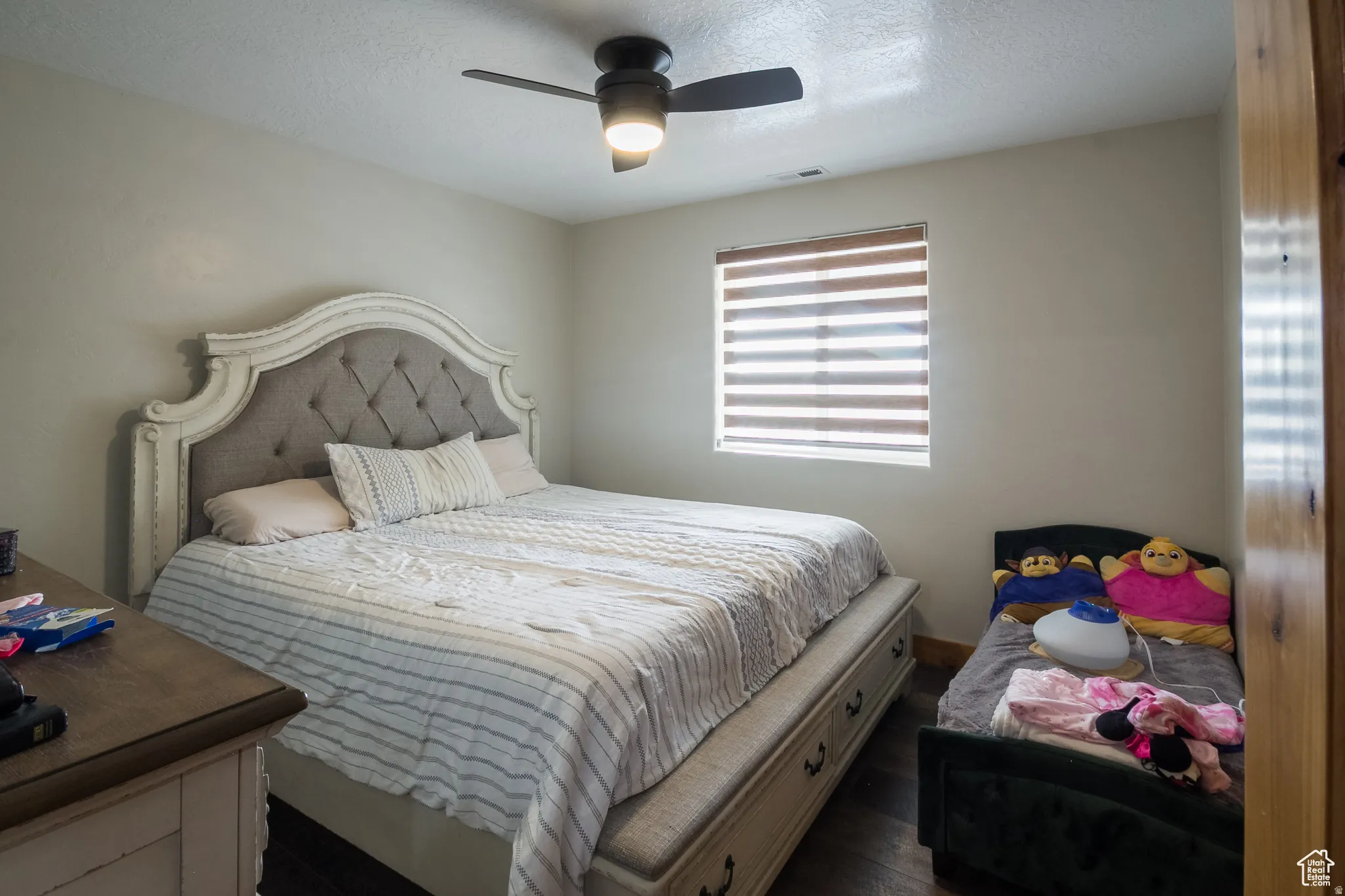 Neutral wall tones complement the dark wood-finish flooring