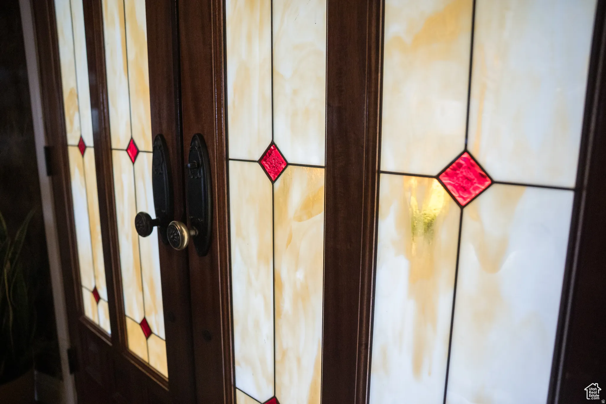 Entryway featuring stained-glass panels with amber and red diamond accents
